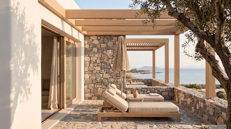 Private stone terrace at Sunset Bay with loungers and an Aegean view